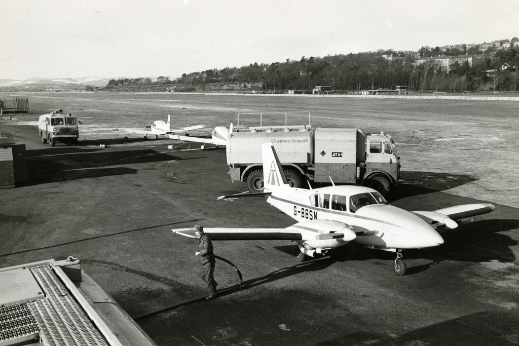 Riverside Drive Airport. Photograph showing a very spacious Riverside Airport, with a few planes standing by as a worker tends to them. 8 February 1979. H262 1979-02-1979 River Side Drive Airport (C)DCT Dundonian.